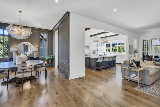 interior space with light wood-type flooring, an inviting chandelier, and plenty of natural light