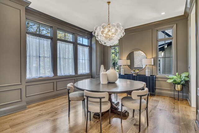 dining room with crown molding, radiator heating unit, a chandelier, and light wood-type flooring