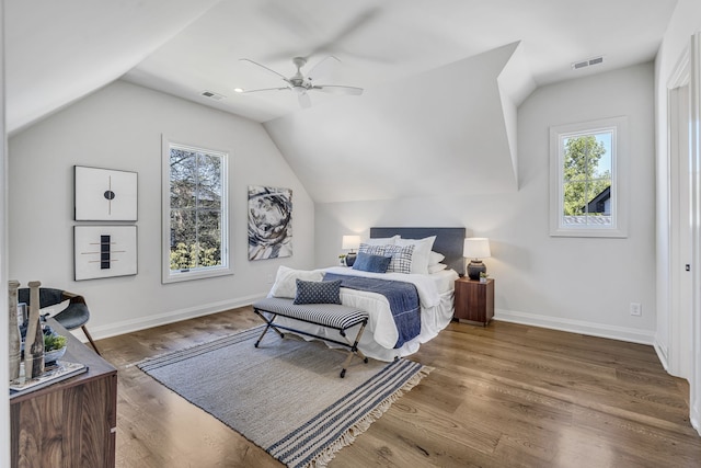 bedroom with dark wood-type flooring, vaulted ceiling, and ceiling fan