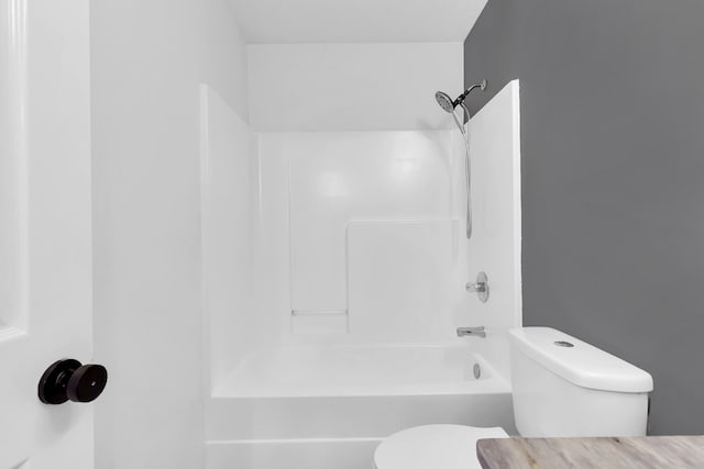 bathroom with bathing tub / shower combination and toilet