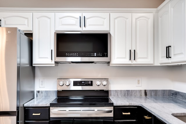 kitchen featuring white cabinetry, stainless steel appliances, and light stone counters