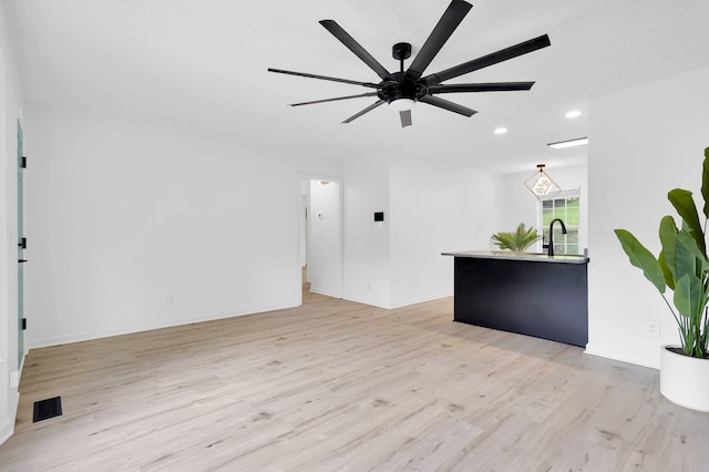 unfurnished living room with light hardwood / wood-style floors and ceiling fan