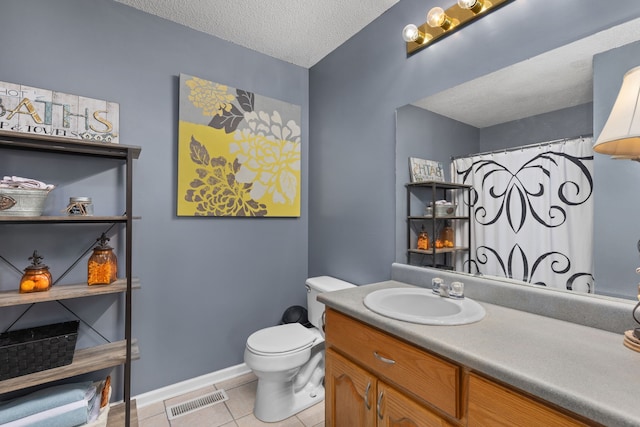 bathroom with vanity, toilet, a textured ceiling, and tile patterned flooring