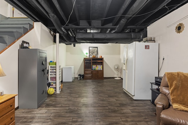 basement with white refrigerator with ice dispenser and dark hardwood / wood-style flooring