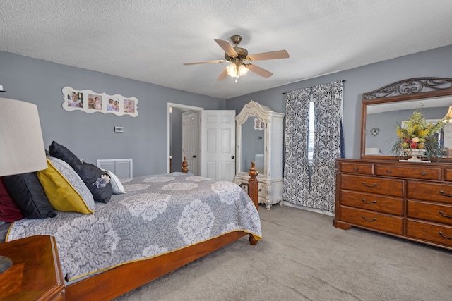 bedroom with light carpet, a textured ceiling, and ceiling fan