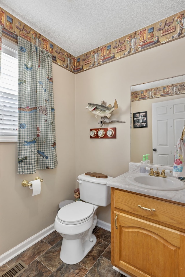 bathroom featuring vanity, a textured ceiling, and toilet