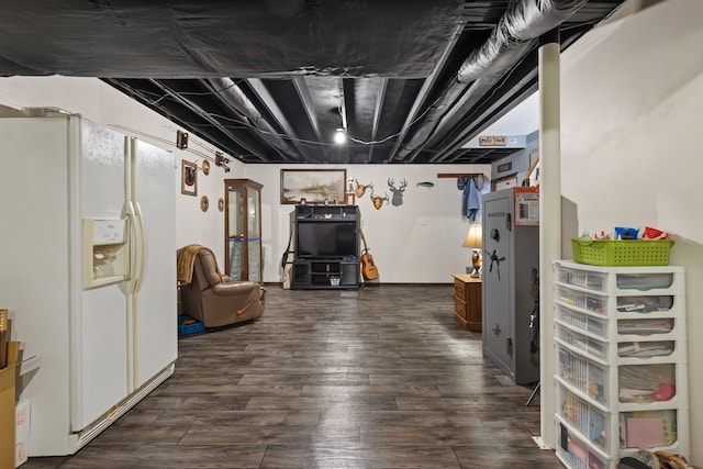 basement featuring white fridge with ice dispenser and dark hardwood / wood-style flooring