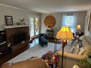 living room with dark wood-type flooring, a fireplace, and crown molding