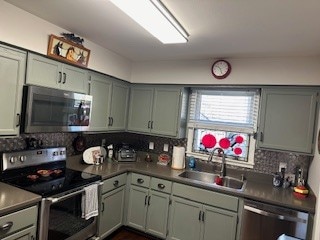 kitchen featuring appliances with stainless steel finishes, decorative backsplash, and sink