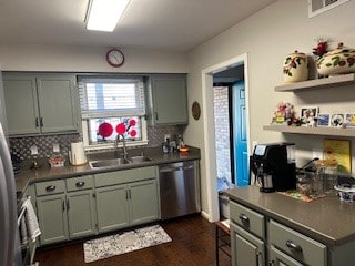 kitchen with sink, appliances with stainless steel finishes, dark wood-type flooring, and tasteful backsplash