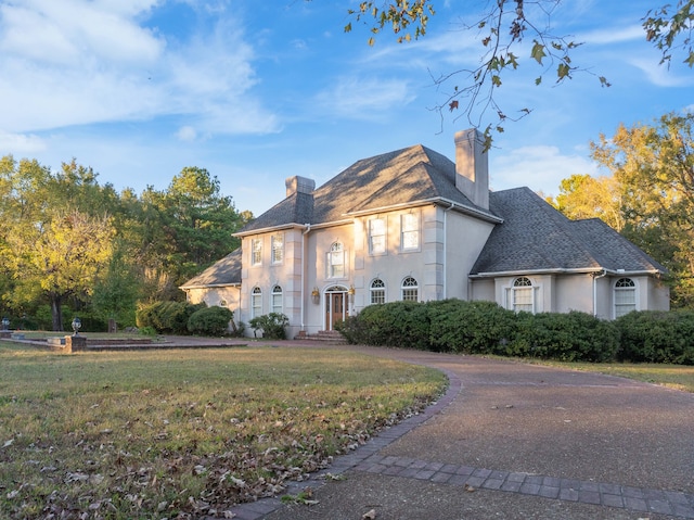 french provincial home featuring a front lawn