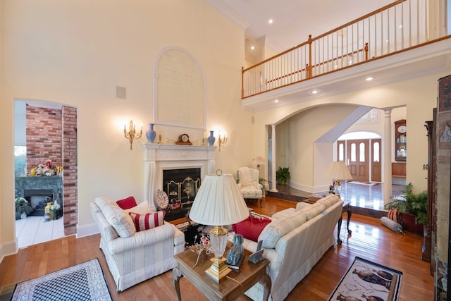 living room featuring a towering ceiling, hardwood / wood-style floors, and a healthy amount of sunlight