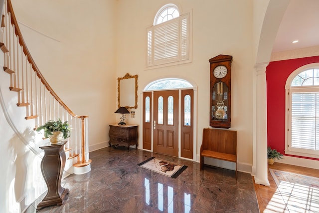 entrance foyer with ornate columns, a high ceiling, and plenty of natural light