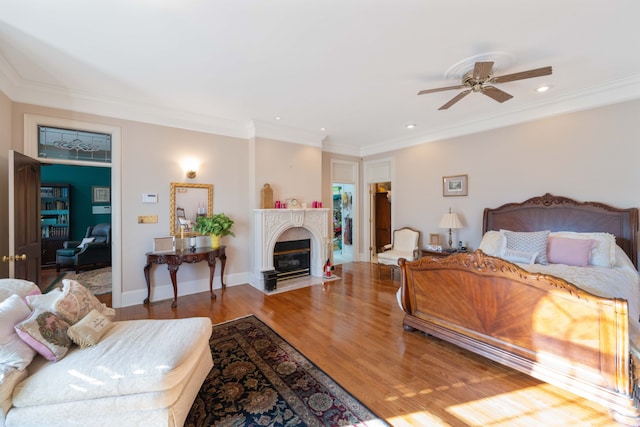 bedroom with crown molding, hardwood / wood-style flooring, and ceiling fan