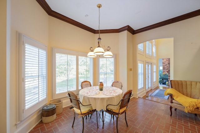 dining area featuring a towering ceiling and ornamental molding