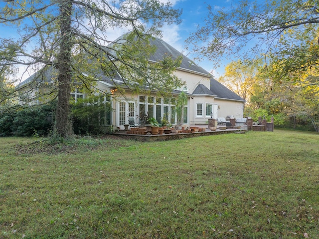 back of property with french doors and a lawn