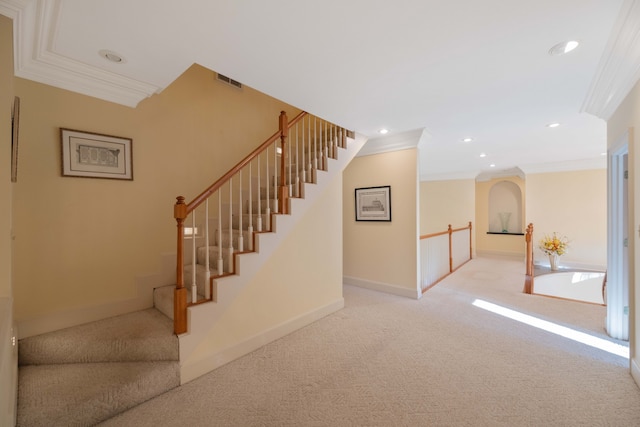 staircase featuring ornamental molding and carpet floors