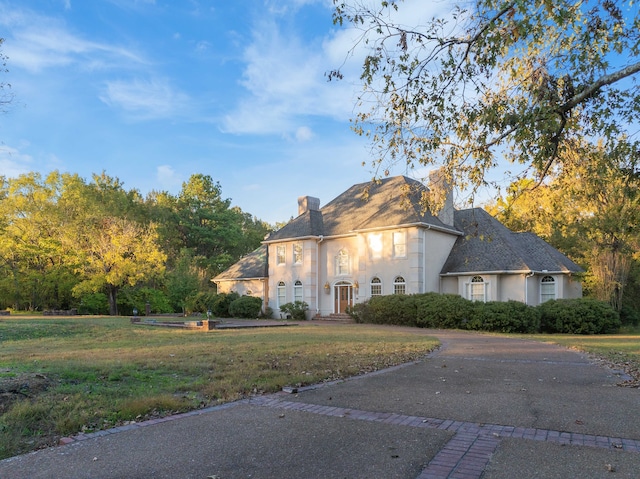 french country inspired facade featuring a front yard