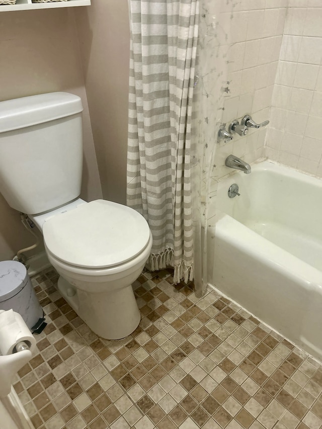 bathroom featuring toilet and shower / bath combination with curtain