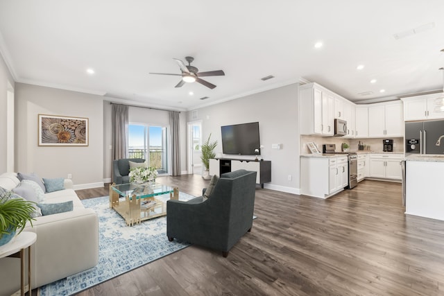 living room with dark wood-type flooring, crown molding, and ceiling fan