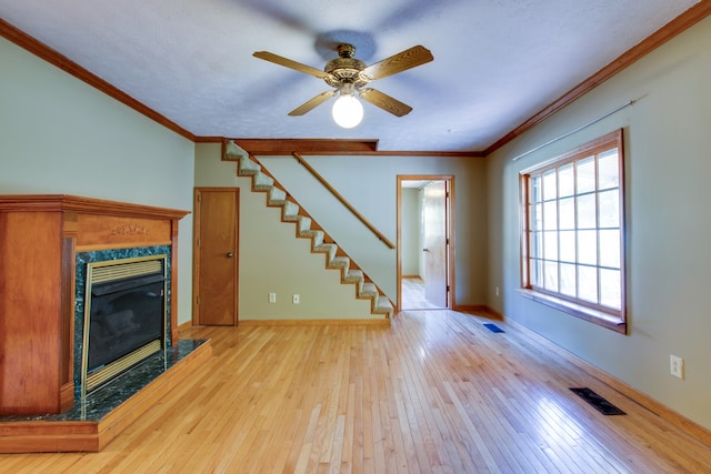 unfurnished living room with ceiling fan, crown molding, and light hardwood / wood-style flooring