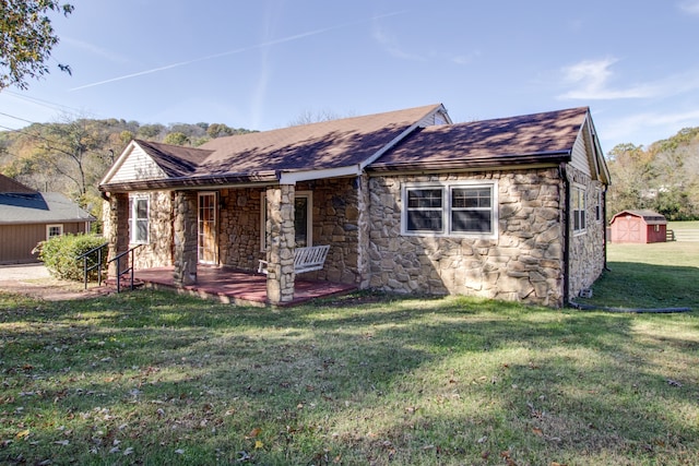 view of front of home featuring a storage shed and a front lawn