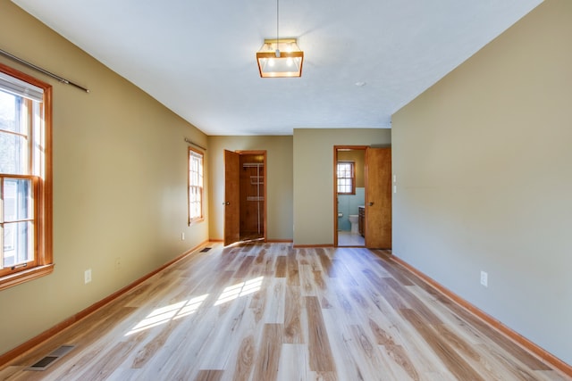 unfurnished room featuring light wood-type flooring and plenty of natural light