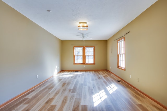 spare room featuring light hardwood / wood-style flooring and ceiling fan