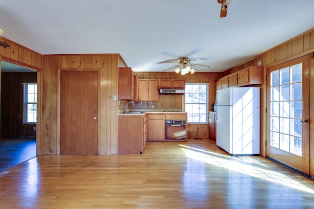 kitchen featuring a healthy amount of sunlight, oven, and white refrigerator