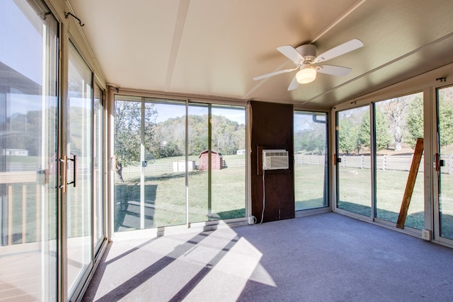 unfurnished sunroom featuring an AC wall unit and ceiling fan