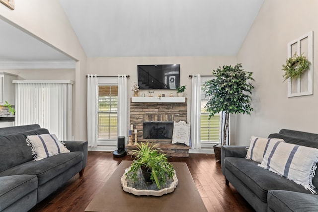 living room featuring dark hardwood / wood-style flooring, a stone fireplace, and vaulted ceiling