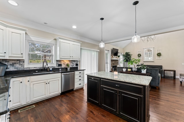 kitchen with hanging light fixtures, stainless steel dishwasher, dark wood-type flooring, a stone fireplace, and sink