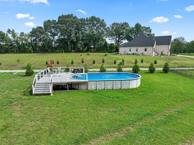 view of pool featuring a rural view, a wooden deck, and a yard