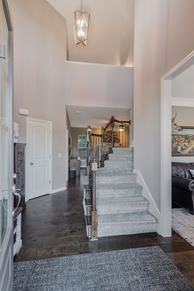 foyer entrance with dark hardwood / wood-style floors and a towering ceiling