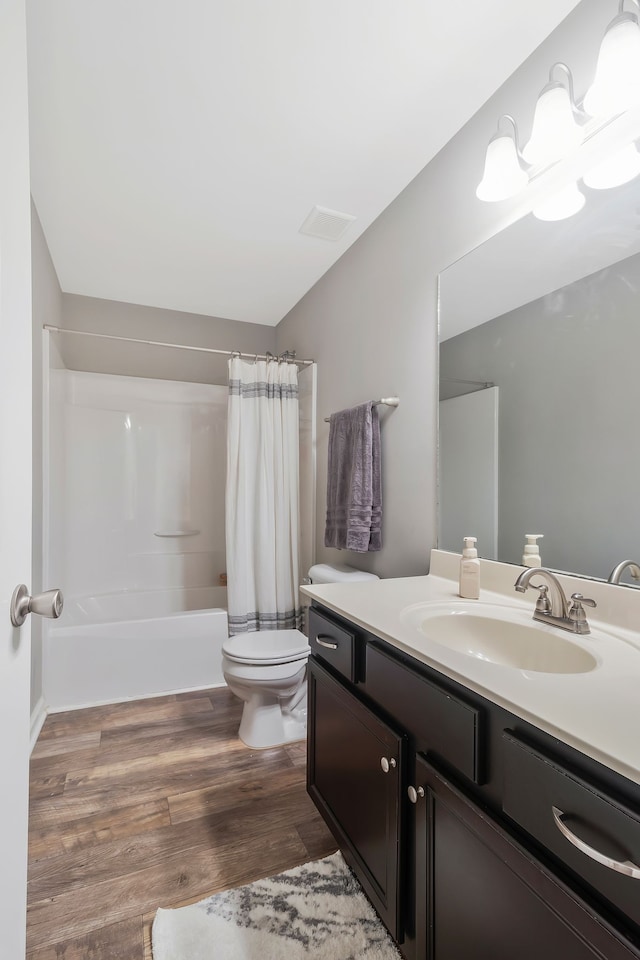 full bathroom featuring vanity, toilet, hardwood / wood-style flooring, and shower / bathtub combination with curtain