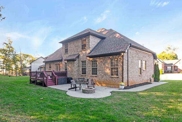 rear view of house with a yard, a patio area, a deck, and a fire pit