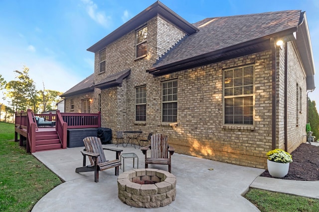 back of property with a patio area, a fire pit, and a deck