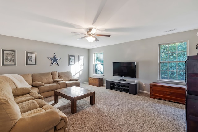 carpeted living room featuring ceiling fan and a wealth of natural light