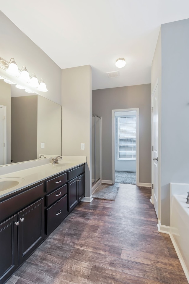 bathroom with vanity, independent shower and bath, and hardwood / wood-style flooring