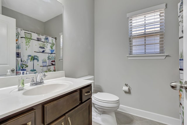 bathroom with toilet, vanity, and tile patterned flooring