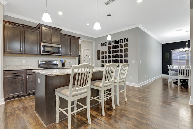 kitchen with a center island with sink, a breakfast bar area, dark wood-type flooring, pendant lighting, and dark brown cabinetry