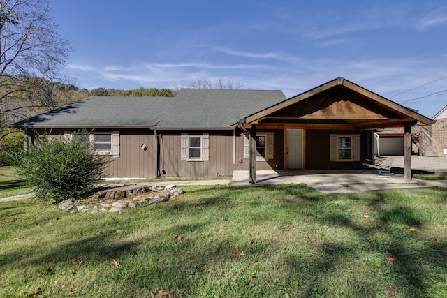 back of house with a patio area and a lawn