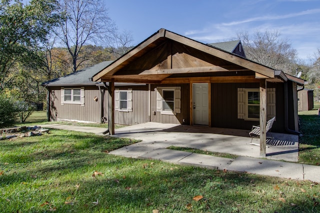 back of property featuring a lawn and a porch