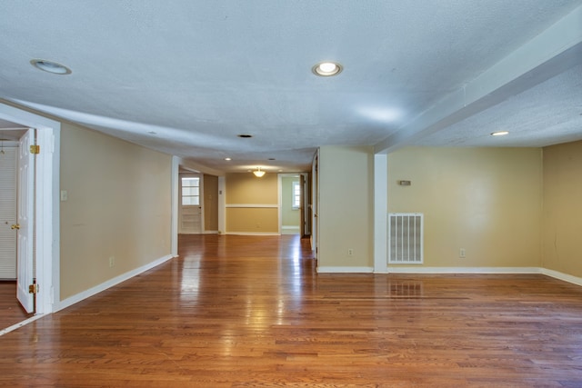 empty room featuring a textured ceiling and hardwood / wood-style flooring