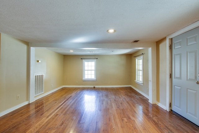 spare room featuring hardwood / wood-style flooring and a textured ceiling