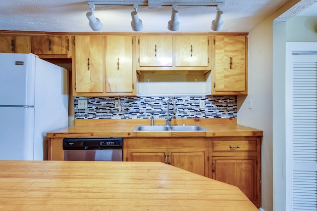 kitchen with dishwasher, wood counters, sink, white fridge, and tasteful backsplash