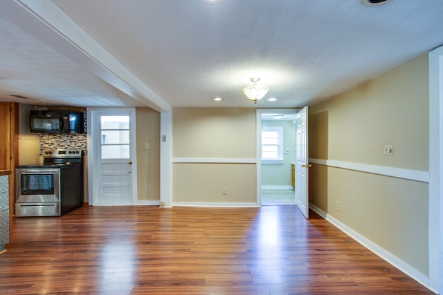 unfurnished living room with dark wood-type flooring and a textured ceiling