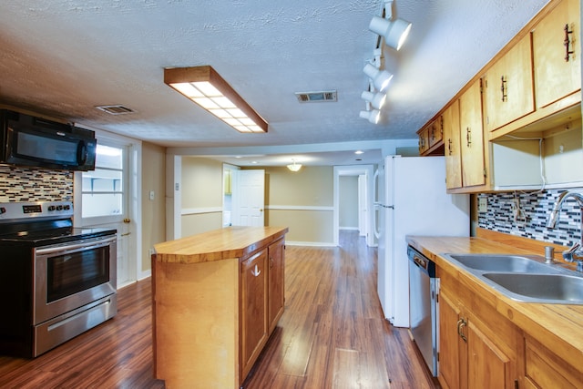 kitchen featuring backsplash, dark hardwood / wood-style flooring, wood counters, sink, and stainless steel appliances