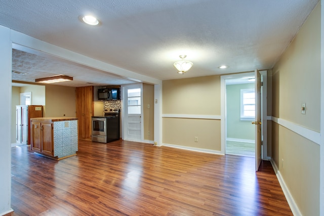 unfurnished living room featuring hardwood / wood-style floors and a textured ceiling