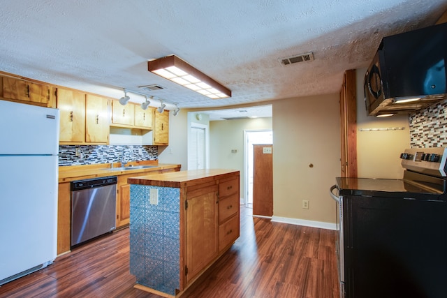 kitchen featuring washer / dryer, appliances with stainless steel finishes, wood counters, a textured ceiling, and dark hardwood / wood-style floors